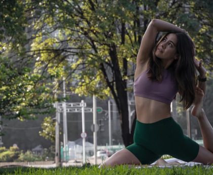 A young woman practices yoga in a lush park in Ciudad de México, surrounded by greenery.